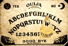 Small yellowed retro oujia board with moving planchette